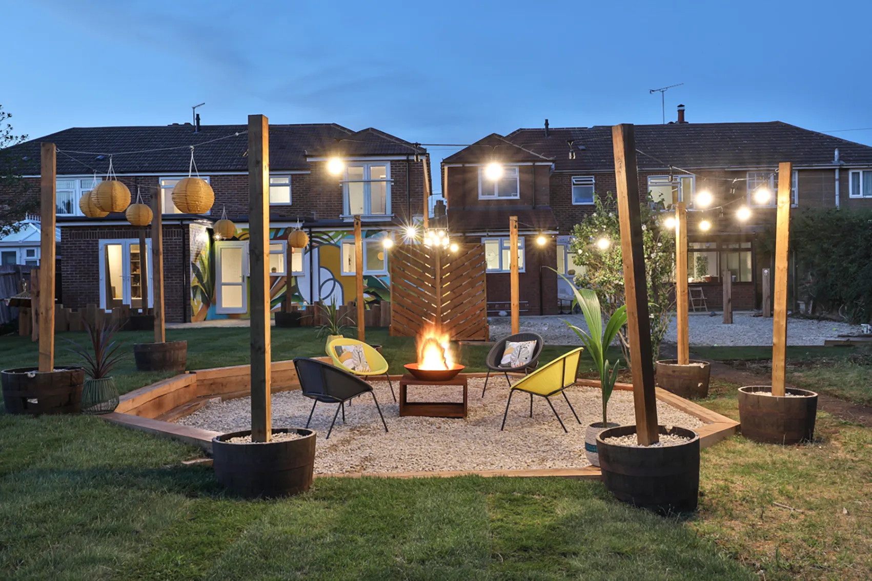 Communal outdoor garden with fire pit and festoon lighting for evening social gatherings in Bicester