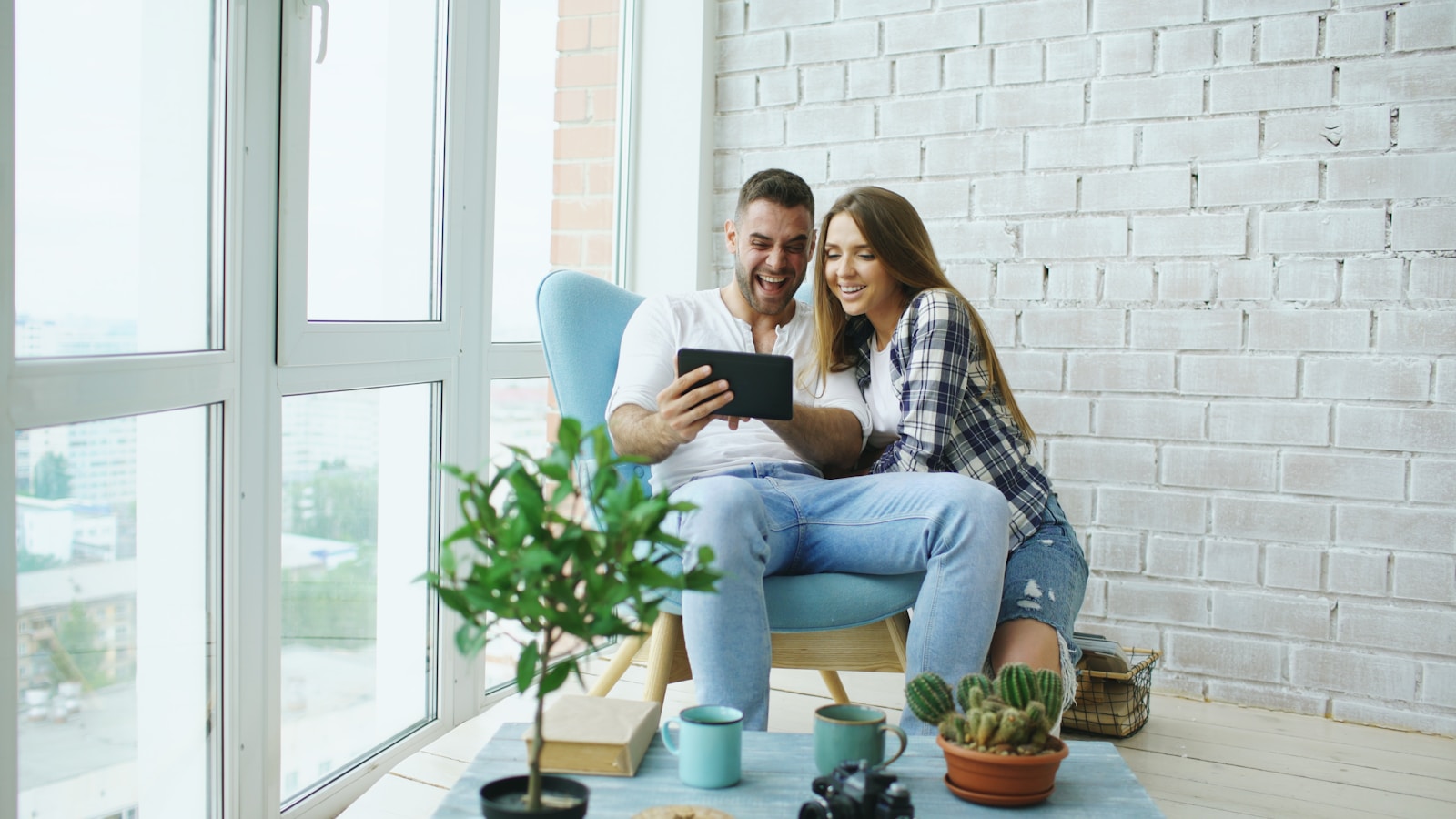 Couple relaxing on an armchair by the window with coffee during daytime rest between shifts